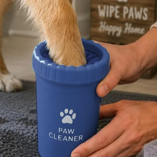 Close-up of the navy Paw Cleaner with a dog's paw in the soft silicone bristles